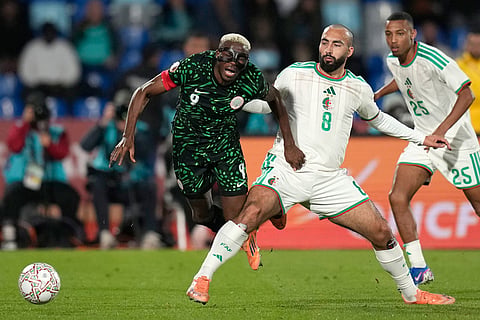Nigeria's Victor Osimhen, left, and Algeria's Himad Abdelli challenge for the ball during the Africa Cup of Nations quarterfinal soccer match between Nigeria and Algeria, in Marrakech, Morocco.