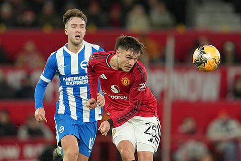 Manchester United's Manuel Ugarte clears the ball in front of Brighton's Jack Hinshelwood during the FA Cup third round soccer match between Manchester United and Brighton in Manchester, England.