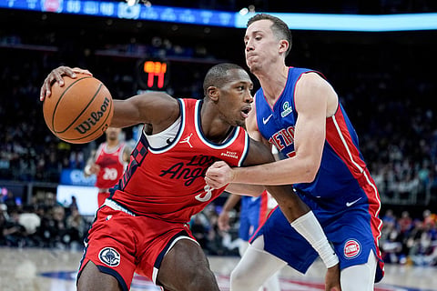 Los Angeles Clippers guard Kris Dunn, left, drives against Detroit Pistons forward Duncan Robinson during the second half of an NBA basketball game in Detroit.