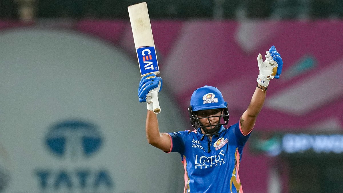 Photo: PTI : Mumbai Indians' captain Harmanpreet Kaur celebrates her half century during a Women's Premier League match against Delhi Capitals.