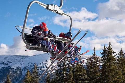 Skier Lauren Macuga, left, looks at her cell phone with ski technician Rok Javor and skier Jackie Wiles as they take the chairlift up the hill for U.S. Women's Ski Team practice at Copper Mountain, Colo.