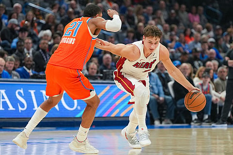 Miami Heat guard Pelle Larsson, right, drives past Oklahoma City Thunder guard Aaron Wiggins, left, during the first half of an NBA basketball game in Oklahoma City.
