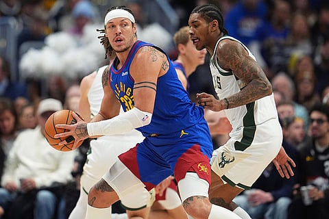 Denver Nuggets forward Aaron Gordon, left, looks to pass the ball as Milwaukee Bucks guard Kevin Porter Jr. defends in the first half of an NBA basketball game in Denver.