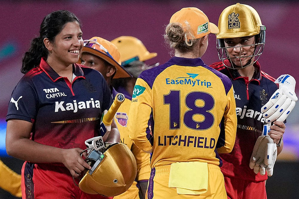 | Photo: PTI/Kunal Patil : Royal Challengers Bengaluru's captain Smriti Mandhana, right, and Richa Ghosh, left, being congratulated by UP Warriorz's Phoebe Litchfield after winning the Women's Premier League (WPL) T20 cricket match between Royal Challengers Bengaluru and UP Warriorz, at the DY Patil Stadium in Navi Mumbai.