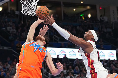 Oklahoma City Thunder center Chet Holmgren, left, goes after a rebound in front of Miami Heat center Bam Adebayo during the second half of an NBA basketball game in Oklahoma City.