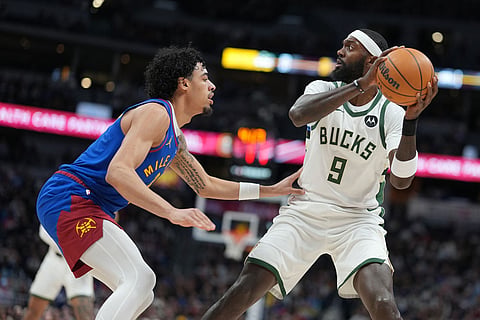 Milwaukee Bucks forward Bobby Portis, right, looks to shoot the ball over Denver Nuggets guard Julian Strawther, left, in the first half of an NBA basketball game in Denver.