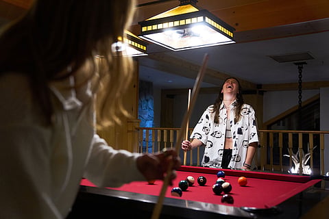 Skier Lauren Macuga, 23, of Park City, Utah, laughs while playing pool with members of the U.S. Women's Ski Team after practice at Copper Mountain, Colo.