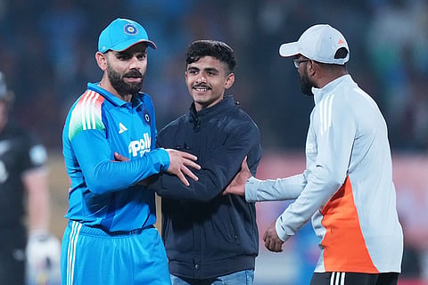 An Indian fan hugs India's Virat Kohli during the second One Day International cricket match between India and New Zealand in Rajkot, India.