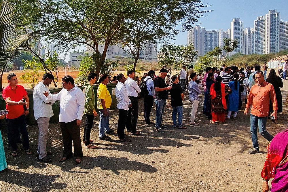 | Photo: PTI : Police personnel stand guard as people wait in a queue to cast votes during the Navi Mumbai Municipal Corporation (NMMC) elections, at a polling station at Kopar Khairane, in Navi Mumbai, Maharashtra.