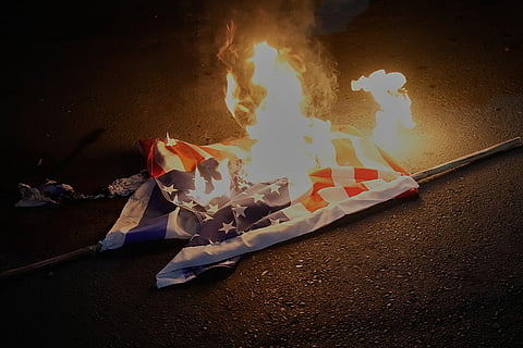 Representations of American and Israeli flags are set on fire during a protest by hardline supporters of the Iranian government, in front of the British Embassy, in Tehran, Iran.