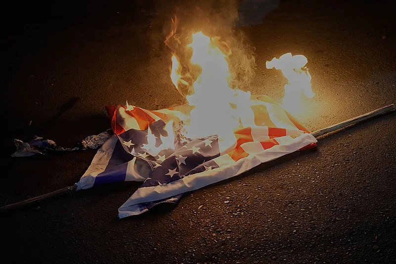 U.S. and Israeli flags are set on fire during a protest by Iranian government supporters