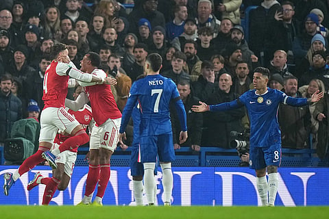 Arsenal's Ben White, left, celebrates with teammates after scoring the opening goal during the English League Cup semifinal first leg soccer match between Chelsea and Arsenal in London.