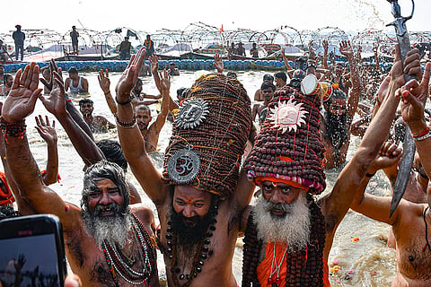Naga sadhus of 'Shri Panch Dashnam Avahan Akhara' arrive to offer prayers and take a holy dip in the river Ganga during the Magh Mela festival at the Sangam, in Prayagraj.