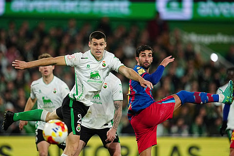Rancing Santander's Alvaro Mantilla, left, vies for the ball with Barcelona's Ferran Torres during the Copa del Rey round of 16 soccer match between Racing Santander and Barcelona, in Santander, Spain.
