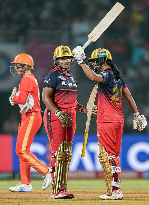 Royal Challengers Bengaluru's Richa Ghosh and Radha Yadav during the Women's Premier League (WPL) T20 cricket match between Royal Challengers Bengaluru and Gujarat Giants, at the DY Patil Stadium, in Navi Mumbai.