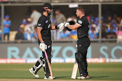 New Zealand's Daryl Mitchell, left, and batting partner Glenn Phillips touch gloves during the third One Day International cricket match between India and New Zealand in Indore, India.
