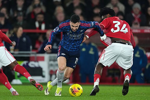 Arsenal's Gabriel Martinelli tries to drive the ball past Nottingham Forest's Ola Aina, right, during the English Premier League soccer match between Nottingham Forest and Arsenal in Nottingham, England.