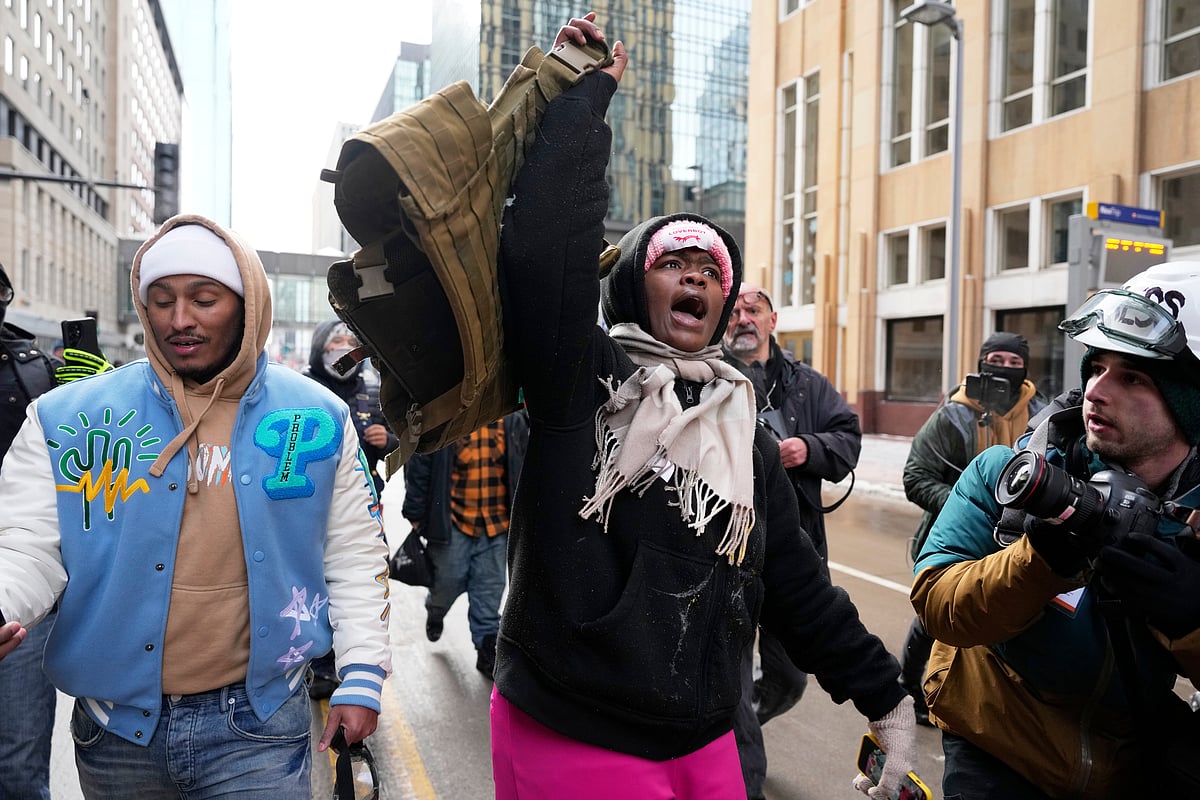 (AP Photo/Yuki Iwamura) : A pro-immigration protester lifts up Jake Lang's vest after an altercation at the March Against Minnesota Fraud rally near Minneapolis City Hall, Saturday, Jan. 17, 2026, in Minneapolis. 