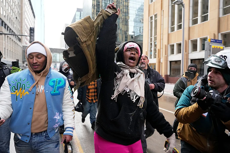 A pro-immigration protester lifts up Jake Lang's vest after an altercation at the March Against Minnesota Fraud rally near Minneapolis City Hall, Saturday, Jan. 17, 2026, in Minneapolis. - (AP Photo/Yuki Iwamura)