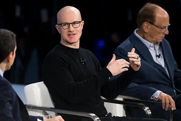 Coinbase CEO Brian Armstrong speaks at a tech conference panel with other men