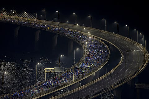 People take part in the 21st edition of the Tata Mumbai Marathon, a World Athletics Gold Label Race, on the Bandra-Worli Sea Link, in Mumbai.