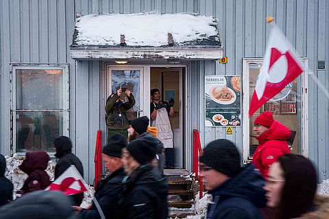 A cafe worker applauds in support of a protest march against Trump's policy towards Greenland in Nuuk.