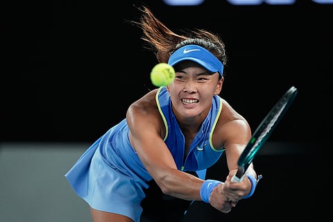 Yuan Yue of China plays a backhand return to Iga Swiatek of Poland during their first round match at the Australian Open tennis championship in Melbourne, Australia.