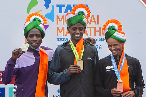 From left, runner-up Leonard Langat, winner Tadu Abate Deme and third-place finisher Merhawi Kesete Weldemaryam in the International Elite Men’s category of the Tata Mumbai Marathon 2026, in Mumbai.