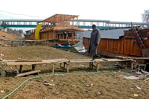 A houseboat owner walks on a footbridge over a dried portion of the Jhelum River, in Srinagar. The meteorological department forecasts spells of wet weather, especially in the higher reaches of the valley, over the next few days. 