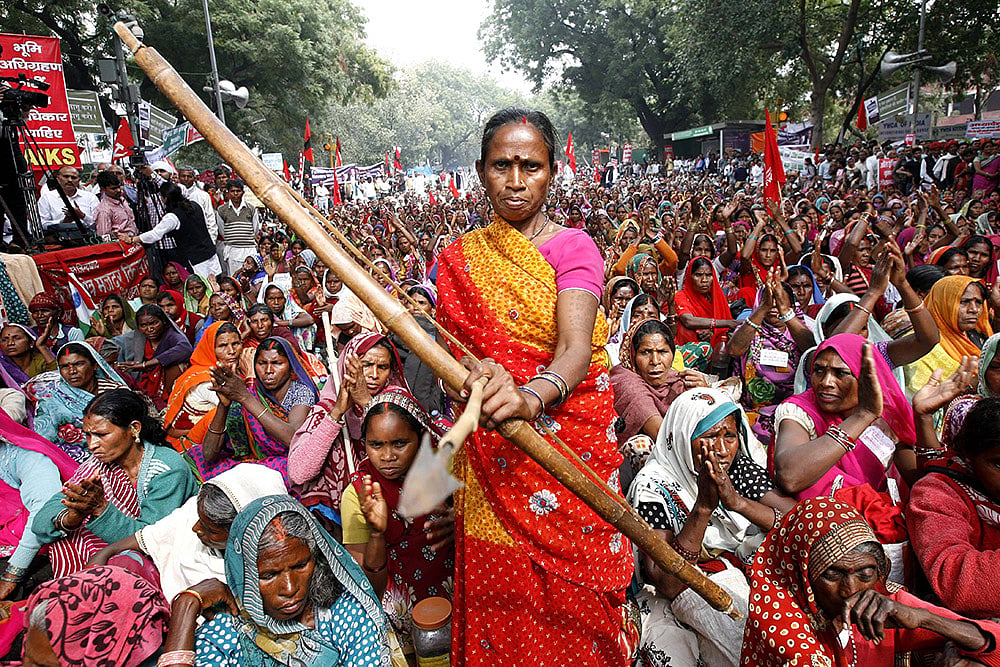 | Photo: IMAGO/Hindustan Times : A tribal supporter of Indian anti-corruption activist Anna Hazare posing with a bow and arrow during a protest at Jantar Mantar.