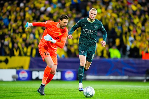 Manchester City's Erling Haaland, right and Glimt's Nikita Haikin battle for the ball during the Champions League soccer match between Bodo/Glimt and Manchester City in Bodo, Norway.