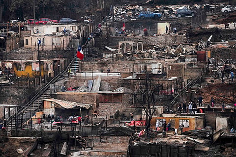 People salvage personnel belongings from their homes that were damaged by wildfires in Lirquen, Chile.
