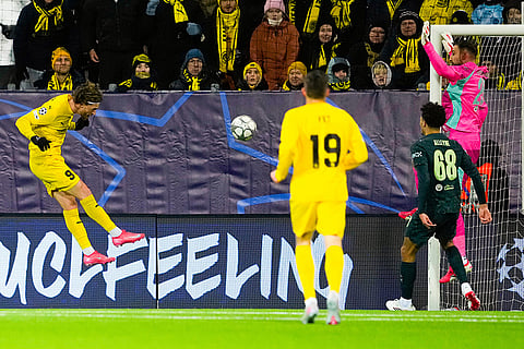 Glimt's Kasper Hogh, left, scores during the Champions League soccer match between Bodo/Glimt and Manchester City in Bodo, Norway.