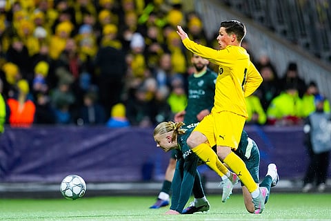 Manchester City's Erling Haaland, center, and Glimt's Sondre Brunstad Fet battle for the ball during the Champions League soccer match between Bodo/Glimt and Manchester City in Bodo, Norway.