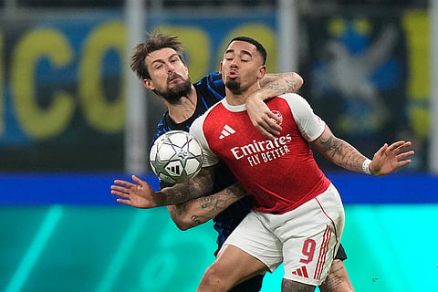 Inter Milan's Francesco Acerbi, left, challenges for the ball with Arsenal's Gabriel Jesus during the Champions League opening phase soccer match between Inter Milan and Arsenal in Milan, Italy.