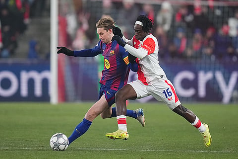 Barcelona's Frenkie de Jong, left, is challenged by Slavia's David Moses during the Champions League opening phase soccer match between Slavia Prague and Barcelona in Prague, Czech Republic.