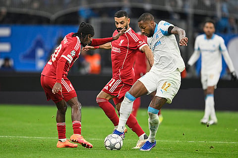 Liverpool's Jeremie Frimpong, left, and Liverpool's Mohamed Salah, centre, challenge for the ball with Marseille's Michael Murillo during the Champions League opening phase soccer match between Marseille and Liverpool in Marseille, France.