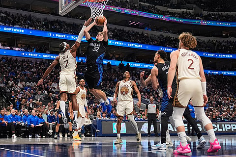 Dallas Mavericks forward Cooper Flagg (32) moves to the basket for a shot as Golden State Warriors' Buddy Hield (7) defends in the second half of an NBA basketball game in Dallas.