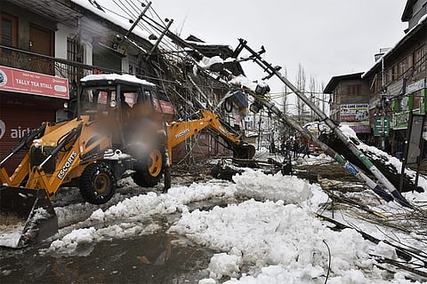 Damaged temporary structures and debris lie scattered in Budgam.