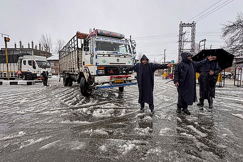 Traffic police personnel regulate vehicles as traffic remains suspended on the Jammu-Srinagar National Highway (NH-44) following fresh snowfall, in Ramban district, Jammu and Kashmir.