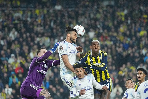 Aston Villa's Tyrone Mings, top, Aston Villa's goalkeeper Marco Bizot, left, and Fenerbahce's Anderson Talisca, right, fight for the ball during a Europa League opening phase soccer match between Fenerbahce and Aston Villa, in Istanbul, Turkey.