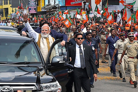 In this image released on Jan. 23, 2026, Prime Minister Narendra Modi greets people during a roadshow upon his arrival, in Thiruvananthapuram.