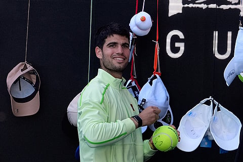 Carlos Alcaraz of Spain signs autographs after defeating Corentin Moutet of France in their third round match at the Australian Open tennis championship in Melbourne, Australia.