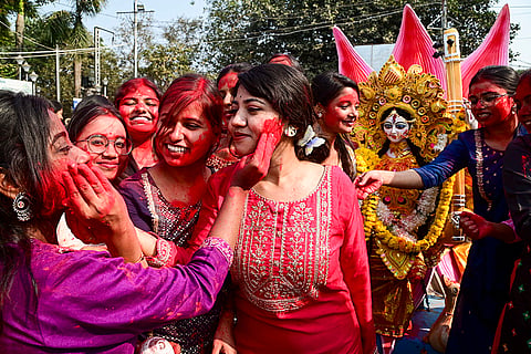 Nursing college students take part in the immersion procession of a Goddess Saraswati idol on the banks of the Hooghly river in Kolkata.