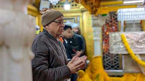 A devotee bows in quiet reverence before the saint's tomb in timeless devotion.