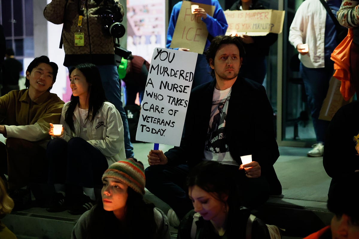  (AP Photo/Caroline Brehman)  : Demonstrator holds a sign during a candlelight vigil during a protest in response to the fatal shooting of 37-year-old Alex Pretti in Minneapolis earlier in the day Saturday, Jan. 24, 2026, in Los Angeles.
