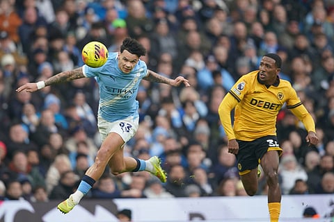 Manchester City's Nico O'Reilly, heads the ball under pressure from Wolverhampton Wanderers' Jackson Tchatchoua during the English Premier League soccer match between Manchester City and Wolverhampton Wanderers in Manchester, England.