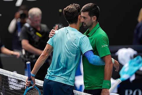 Lorenzo Musetti, left, of Italy embraces Novak Djokovic of Serbia after retiring from their quarterfinal match at the Australian Open tennis championship in Melbourne, Australia.