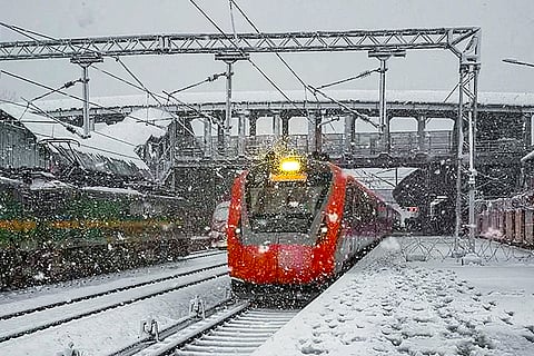 A train moves amid snowfall on the Katra-Srinagar rail section, in Srinagar, Jammu and Kashmir.
