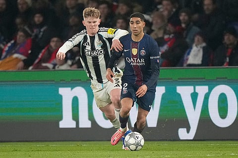 PSG's Achraf Hakimi, right, is challenged by Newcastle's Lewis Hall during a Champions League opening phase soccer match between Paris Saint-Germain and Newcastle in Paris.